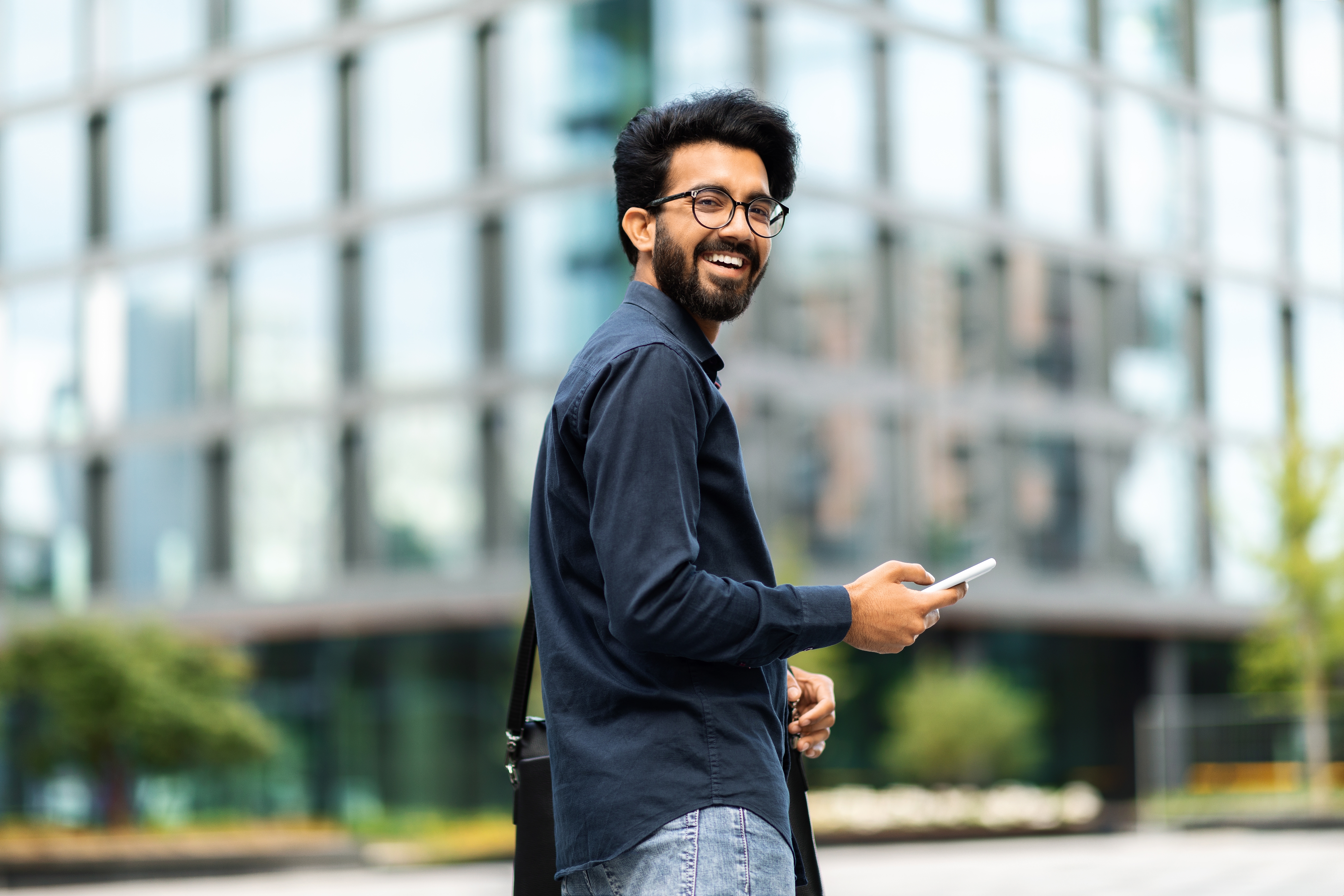 man standing with cellphone in downtown city