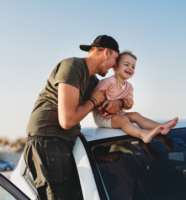 Father and son at car