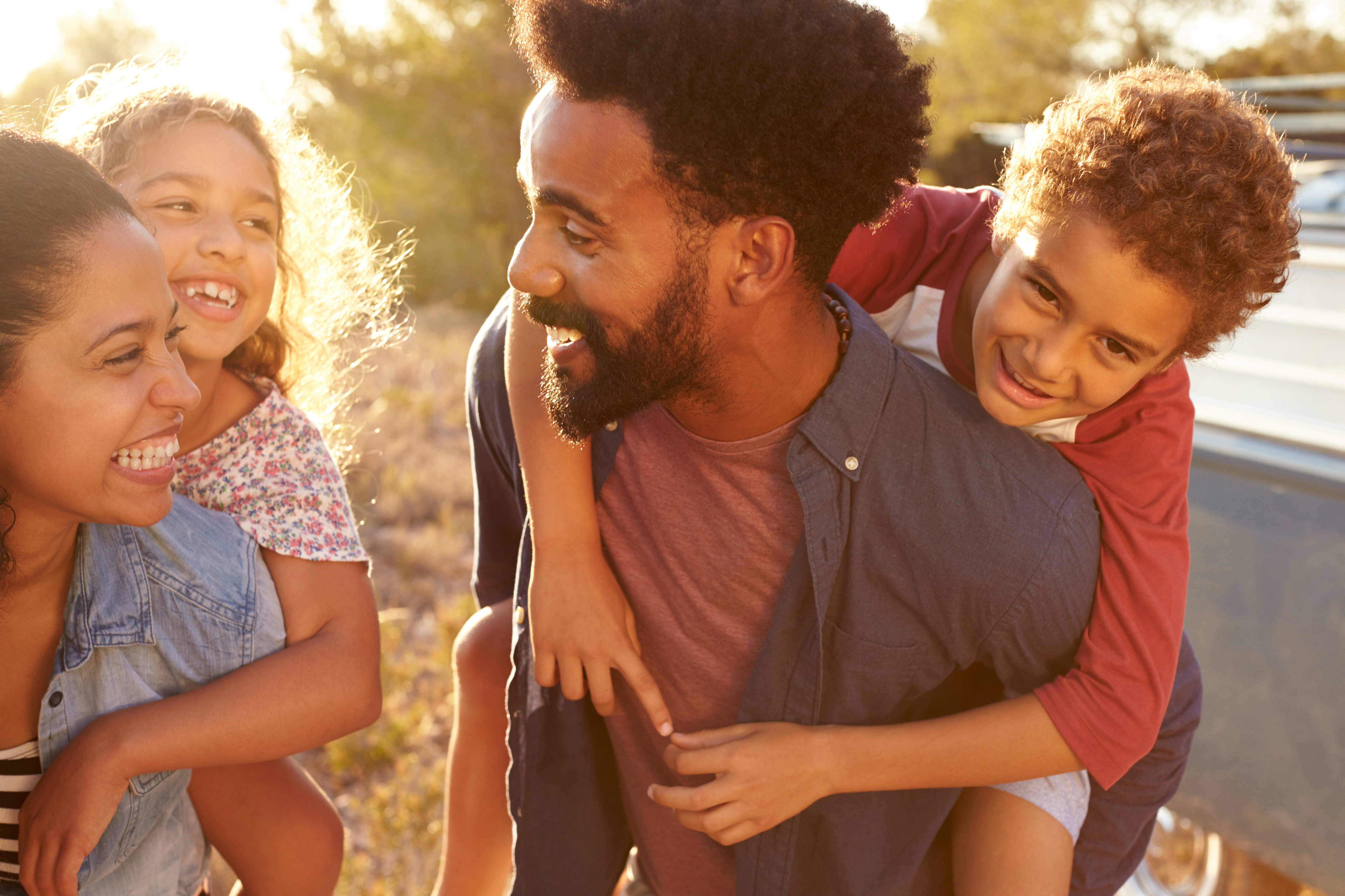 man and woman laughing with their children