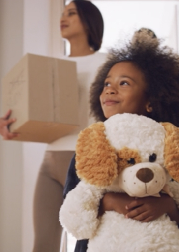 Young girl with stuffed animal in new home