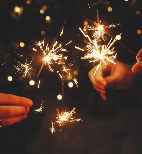 People holding lit sparklers