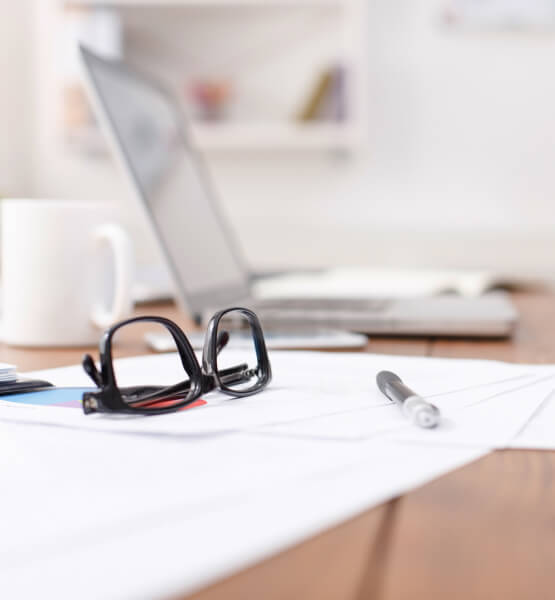 glasses and laptop sitting on desk